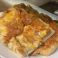 Cheesy garlic bread baked until golden brown and served on a white plate.