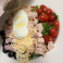 Chef salad with turkey, ham, hard-boiled egg, cheese, olives, tomatoes, and fresh greens.