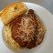 Chicken Parmesan topped with marinara sauce and melted cheese, served with pasta and garlic bread.