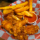 Buffalo-style chicken wings served with thick-cut fries and dipping sauce.