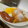 French toast with bacon and scrambled eggs dusted with powdered sugar.