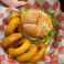 Cheeseburger topped with lettuce, tomato, onion, and melted cheese served with golden onion rings.