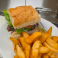 Marinated steak sandwich served on toasted bread with thick-cut fries and a pickle spear.