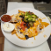 Loaded nachos with cheese, olives, tomatoes, jalapeños, avocado, salsa, and sour cream.