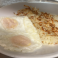 Two eggs served with golden brown crispy hash browns.
