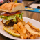 Club-style sandwich served on fresh bread with thick-cut fries and a pickle spear.