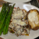 Smothered chicken breast with mushrooms, peppers, melted cheese, asparagus, and baked potato.